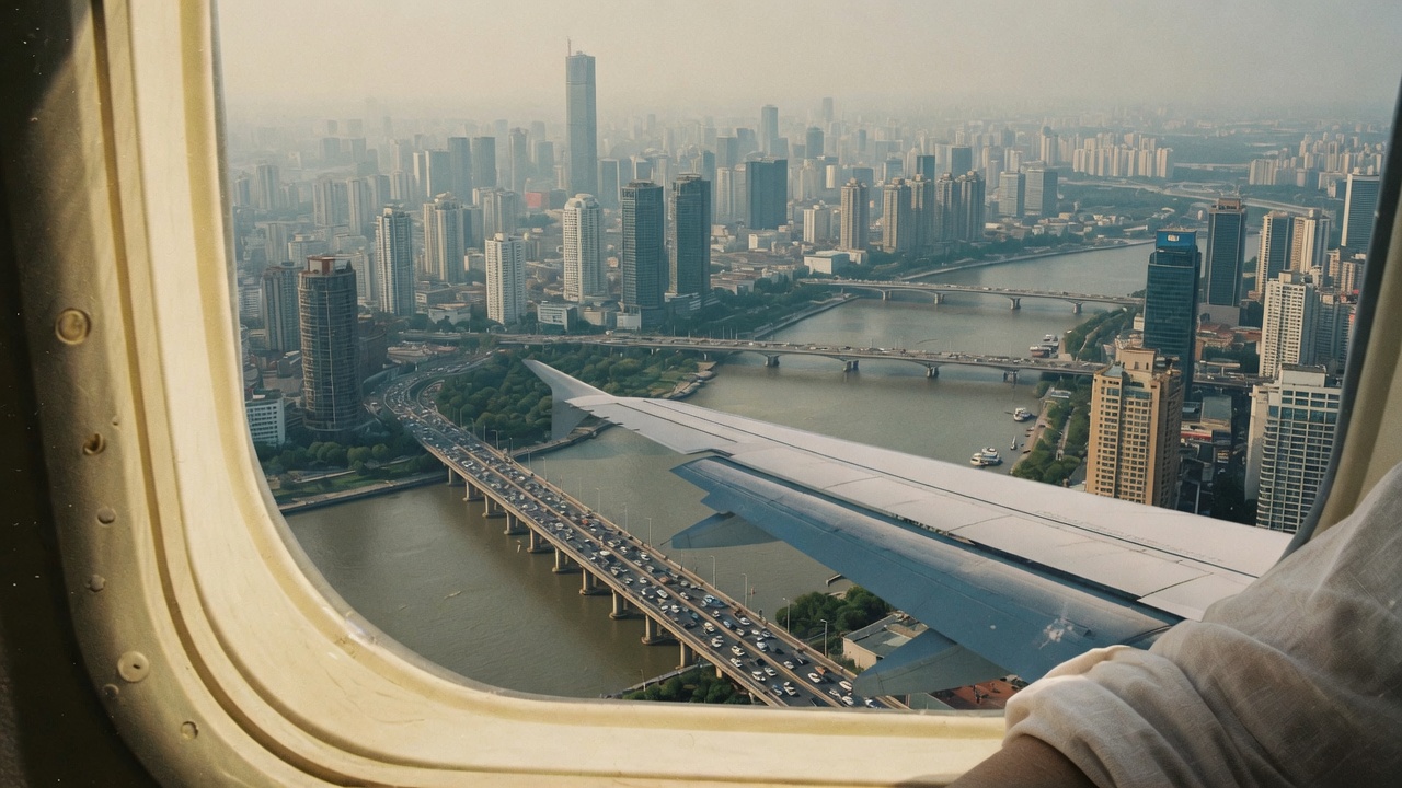 Airplane window on approach over a dense city.